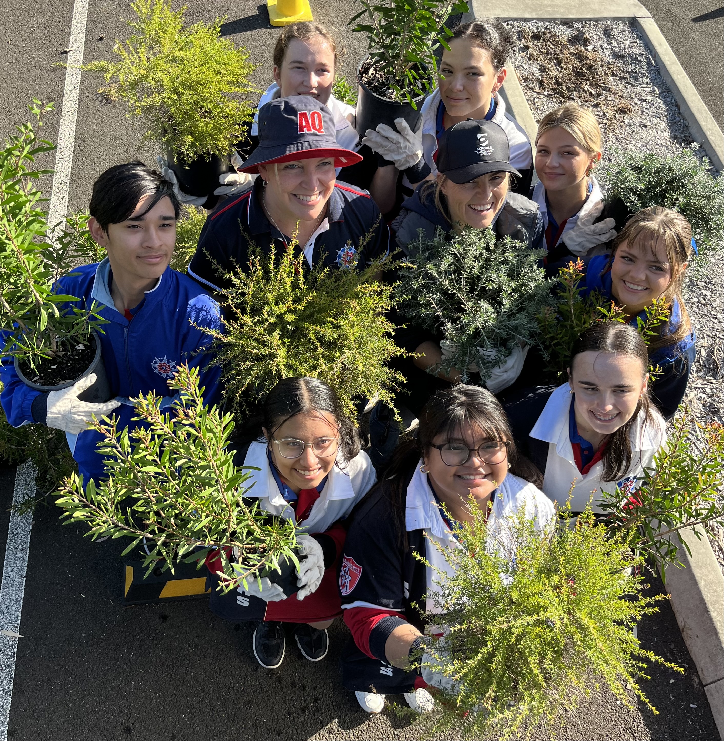 Group of students holding plants.